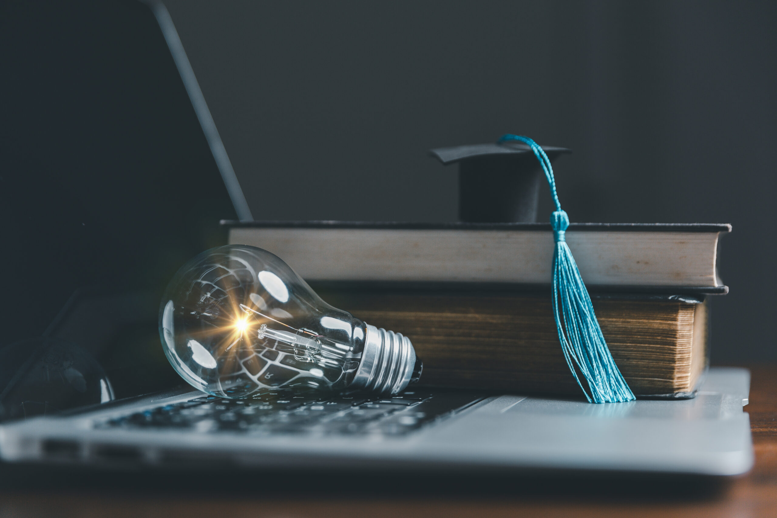 Light bulbs and books with graduation hat Concept of reading books, knowledge, and searching for new ideas Innovation and inspiration, Creativity with twinkling lights, the inspiration of ideas